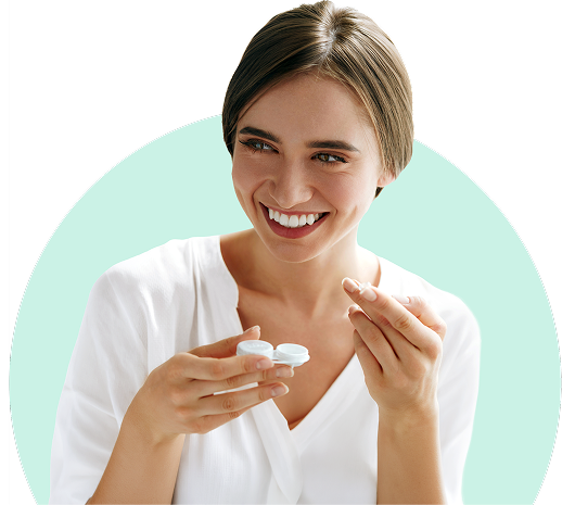 A woman smiling as she puts in her contact lenses.