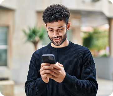 A young man looking at his phone in a medical office.